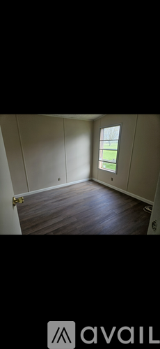 A room with wooden flooring and a window.