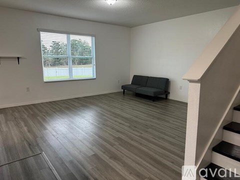 A living room with a couch and a staircase.