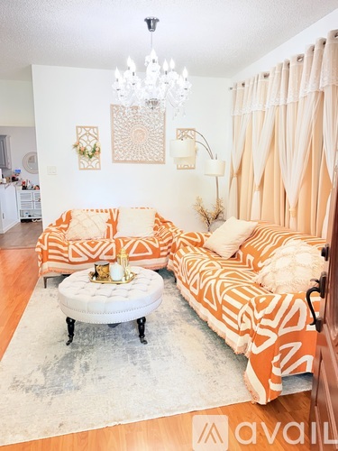 A bedroom with two beds and a chandelier.