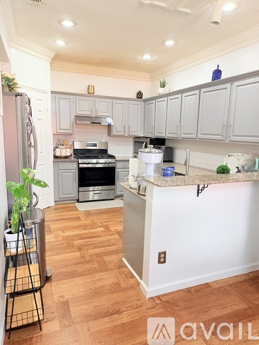 A kitchen with a white island and wooden floors.