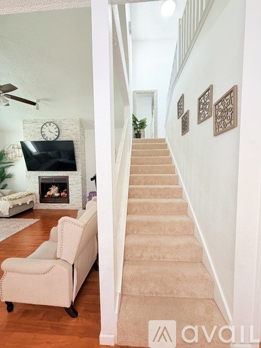 A living room with a white couch and a fireplace.