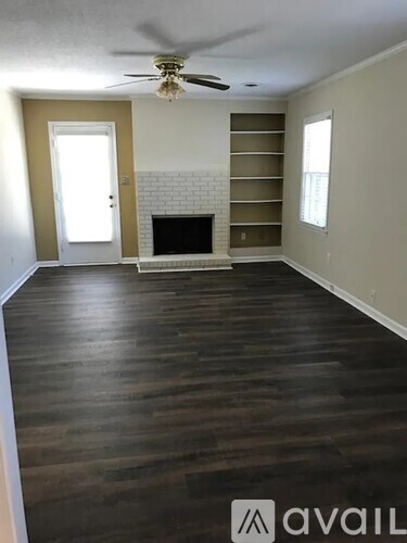 A living room with a fireplace and a ceiling fan.