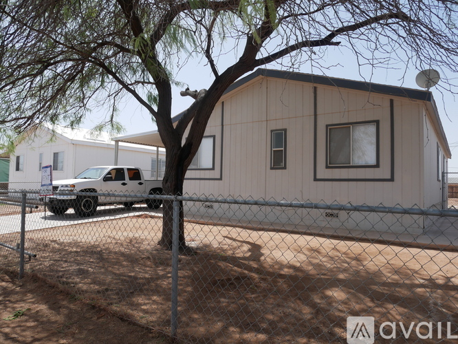 A house with a tree in front of it and a truck parked in front of the house.