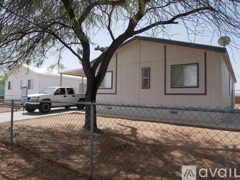 A house with a tree in front of it and a truck parked in front of the house.