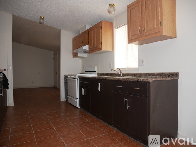 A kitchen with brown cabinets and a black countertop.
