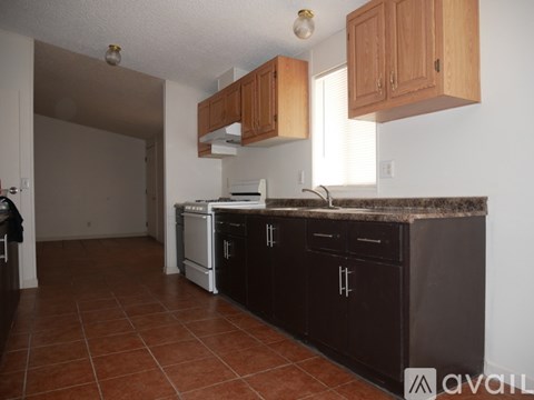 A kitchen with brown cabinets and a black countertop.