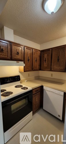 A kitchen with wooden cabinets and a white stove top oven.