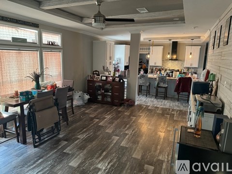 A living room with a wooden floor and a ceiling fan.