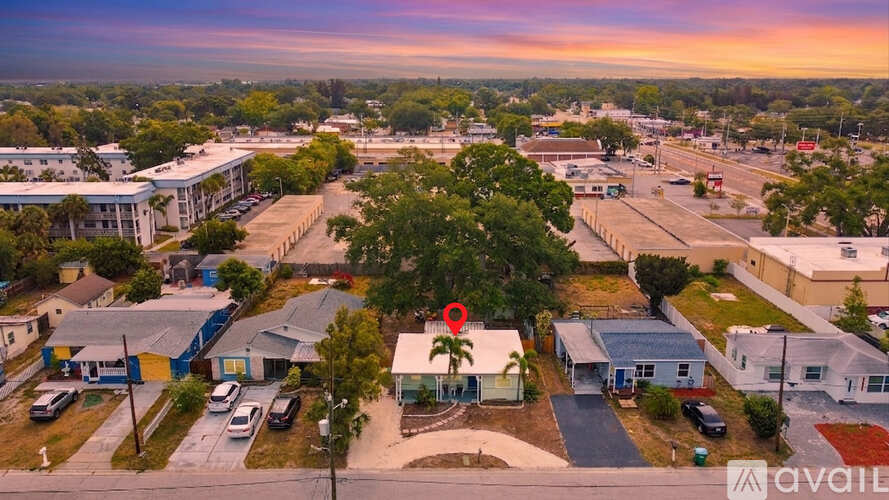 A sunset view of a small town with a few buildings and cars.