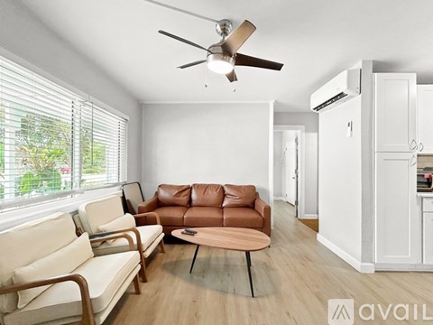 A living room with a brown leather couch and a white sofa.
