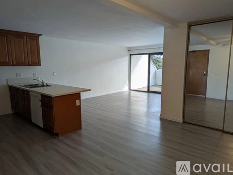 A kitchen with wooden cabinets and a white countertop is available for rent.