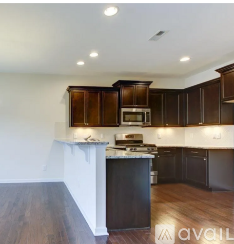 A kitchen with dark wood cabinets and a white counter.