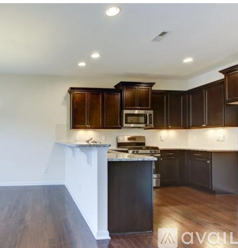 A kitchen with dark wood cabinets and a white counter.
