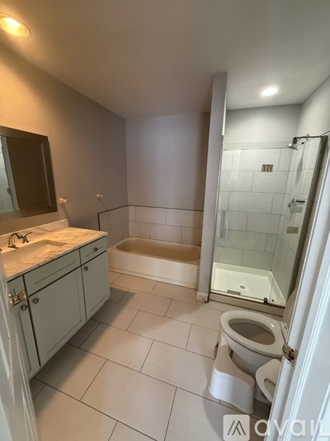 A white bathroom with a toilet, sink, and bathtub.