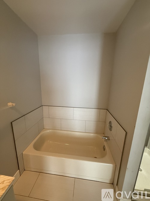 A white bathroom with a bathtub and tiled walls.