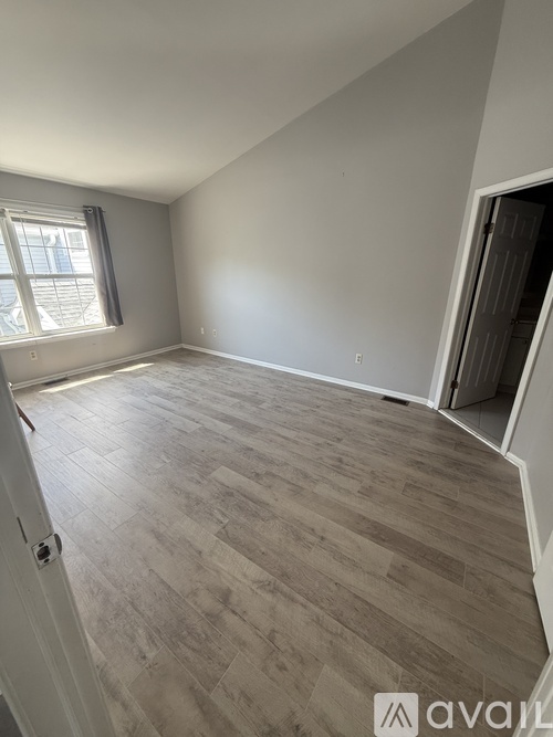 A room with light grey walls and a wooden floor.