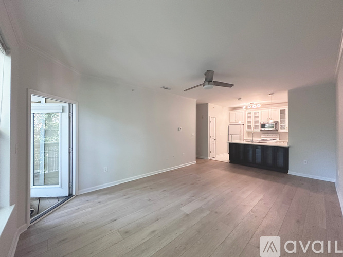 A spacious room with wooden flooring and a ceiling fan.