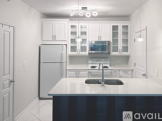 A kitchen with white cabinets and a white refrigerator.