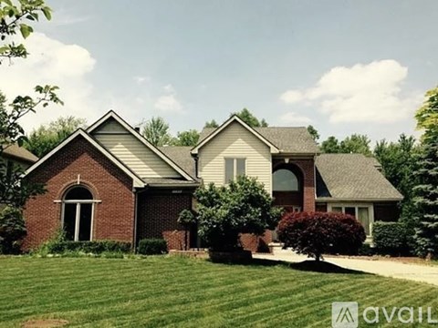 A house with a well-maintained lawn and a clear sky.