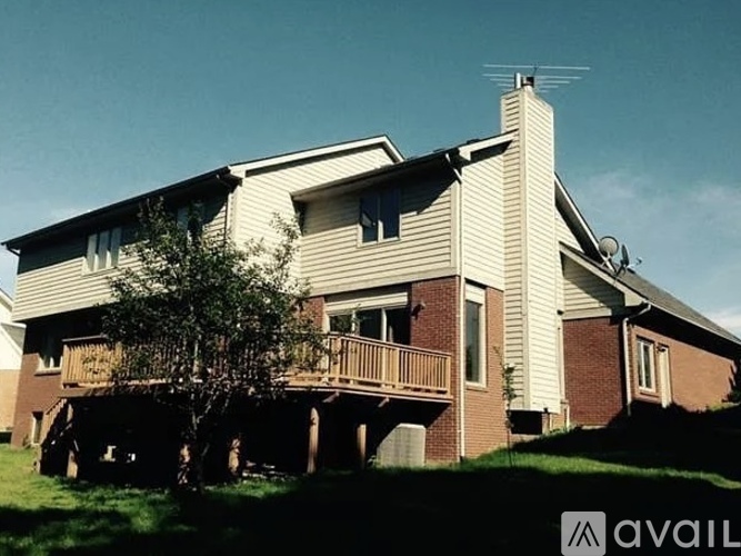 A house with a balcony and a tree in front of it.