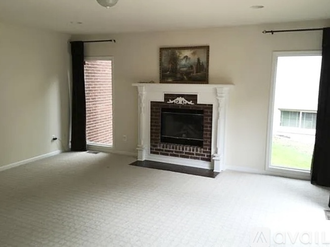 A living room with a fireplace and a painting above it.
