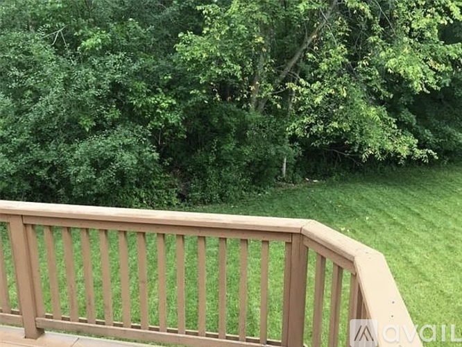 A wooden railing overlooking a lush green lawn.
