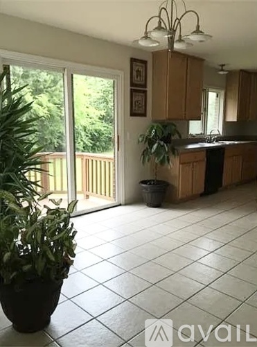 A kitchen with a tile floor and wooden cabinets.