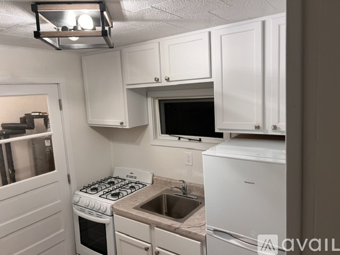 A kitchen with white cabinets and a stove top oven.