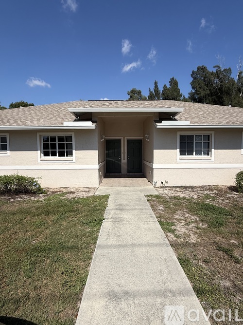 A house with a concrete walkway leading to the front door.
