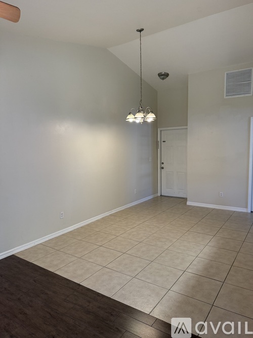A room with a white wall and a brown floor.