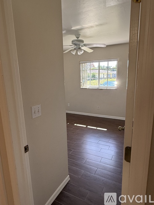 A room with a ceiling fan and a window.