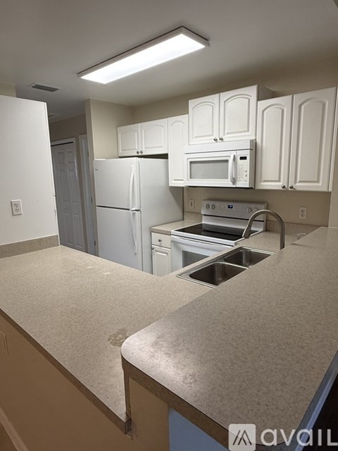 A kitchen with white cabinets and appliances.
