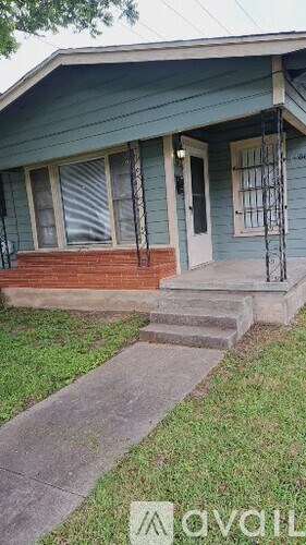 A blue house with a white door and a metal railing on the steps.