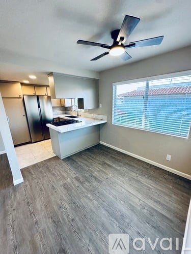 A kitchen with a fan and a window with blinds.
