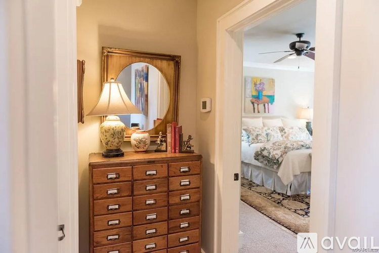 A bedroom with a bed, a dresser with a mirror, and a ceiling fan.