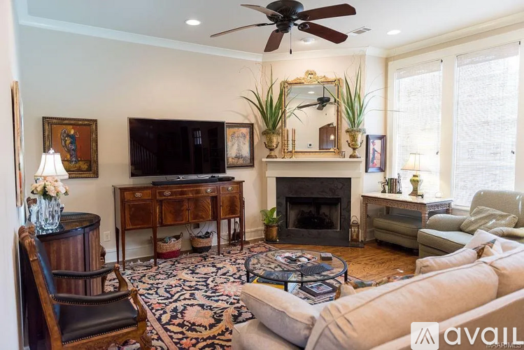 A living room with a fireplace, a television, and a chair.