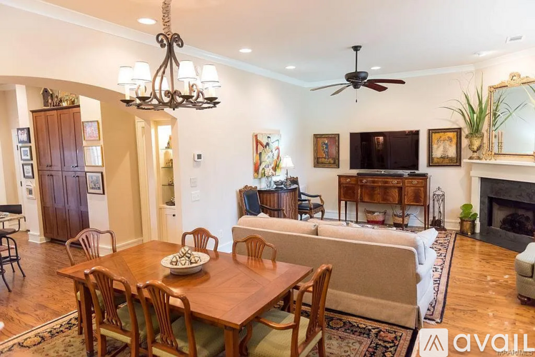 A well-lit living room with a dining table and chairs.