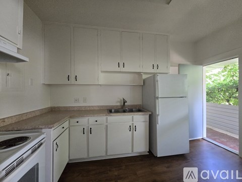 A kitchen with white cabinets and appliances.