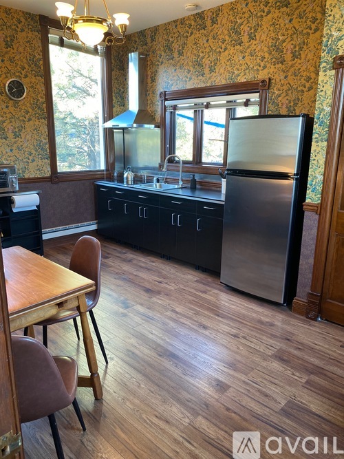 A kitchen with a wooden table and chairs.