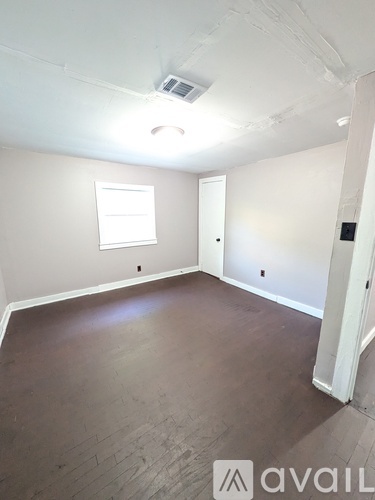 A room with a window and a door is available for rent.