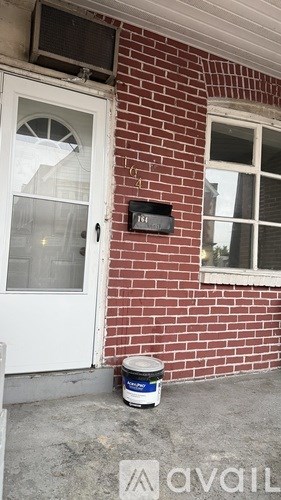 A red brick house with a white door and window.