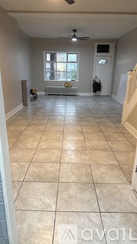 A room with tiled flooring and a ceiling fan.