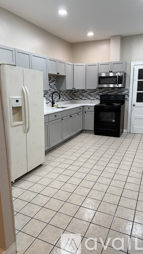 A kitchen with white cabinets and a black oven.