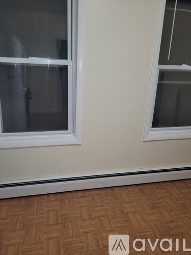 A room with a window and a wooden floor.