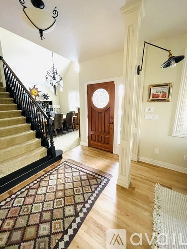A hallway with a wooden door and a rug on the floor.