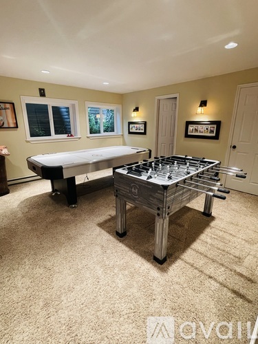 A room with a pool table and a foosball table.
