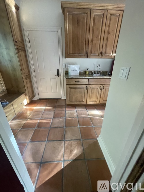A kitchen with wooden cabinets and a tiled floor.