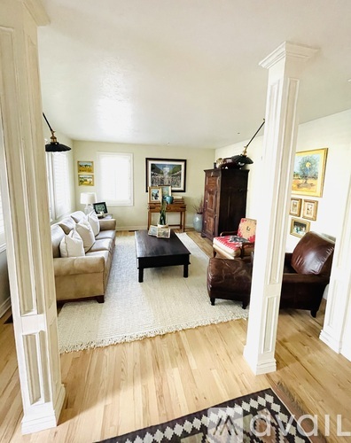 A living room with a brown leather couch and a wooden coffee table.