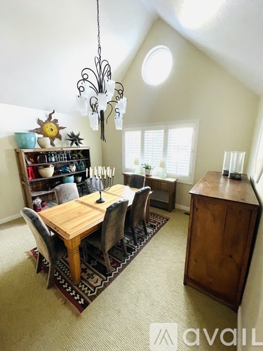 A dining room with a wooden table and chairs.