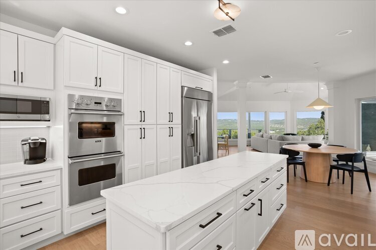 A modern kitchen with white cabinets and a large island.